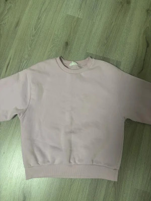 Rosa sweatshirt från Gina Tricot - Säljer en rosa sweatshirt från Gina Tricot, basically basics-kollektionen. Tröjan har rund halsringning, ribbade muddar och är gjord i mjukt material. Perfekt för en chill och avslappnad stil.