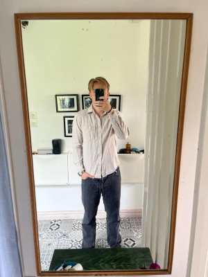 Beige Linneskjorta S - Säljer en stilren beige linneskjorta med långa ärmar och klassisk krage. Skjortan har knäppning framtill och en rak passform som funkar till många olika looks. Perfekt för dig som gillar enkel och clean stil.