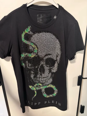 Philipp Plein T-shirt - T-shirt från Philipp Plein, motiv av Swarovski kristaller. Saknas 2-3 kristaller men absolut inget som syns. Medföljer tags och extra kristaller.  
