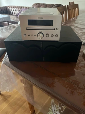 Yamaha minianläggning med högtalare - Säljer en stilren Yamaha minianläggning modell CRX-330 i silver med tillhörande svarta högtalare. Anläggningen har CD-spelare, radio och flera anslutningsmöjligheter på baksidan. Perfekt för dig som vill ha bra ljud i ett kompakt format.