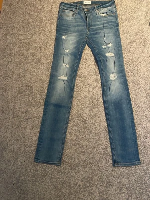 Ljusblå slitna jeans - Säljer ett par ljusblå jeans från Jack and Jones i storlek 30 32. Sitter prima ballerina på mig som är 180 mc och 67 kg. Skickar gärna fler bilder om du vill.