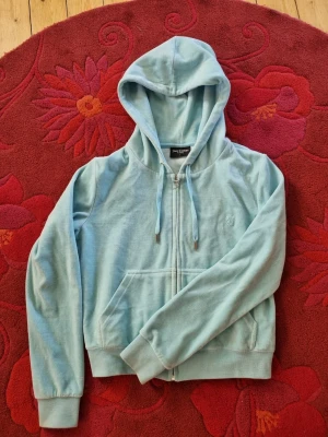 Ljusblå Juicy Couture hoodie - Ljusblå hoodie från Juicy Couture i velourmaterial. Är i princip helt oanvänd. Nypris 1300.