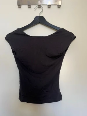 Mörkgrå topp med öppen rygg  - En stilren topp med öppen rygg från Gina Tricot, storlek Xs
