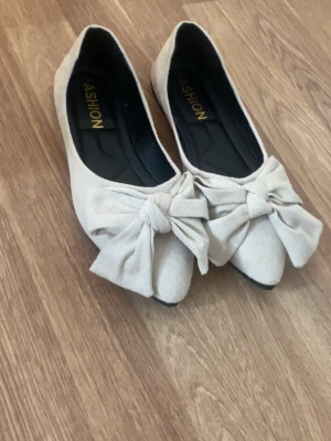 Ballerinaskor med rosetter - Superfina, oanvända beiga ballerina skor med stora rosetter där fram❤️ 