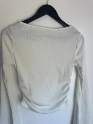 Vit ribbad långärmad topp från Romwe - Säljer en vit långärmad topp från Romwe i storlek M. Toppen är ribbad och har en enkel, stilren design med rundad halsringning. Perfekt att matcha med jeans eller kjol för en clean look.