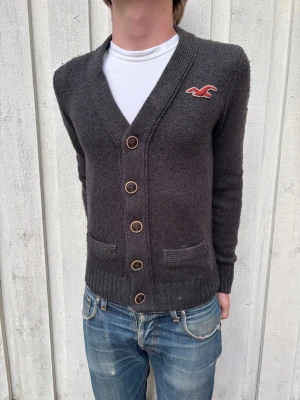 Stickad Hollister Cardigan - En sjukt snygg stickad cardigan med extremt bra passform, något nopprig. Passar S/M. Modellen är 178 cm och väger 68 kg. Hör av dig vid frågor! 