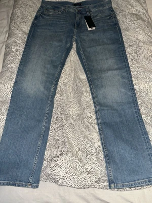 Ljusblå raka jeans Tommy Hilfiger - Snygga ljusblå jeans från Tommy Hilfiger med raka ben och klassisk femficksmodell. Jeansen har en diskret tvättad look och är tillverkade i denim. Perfekta för en avslappnad och trendig stil.