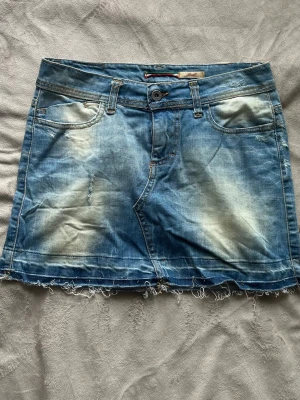 Blå Vintage Jeanskjol med fransig kant - Gullig kort vintage jeanskjol med ett hjärta vid högra bakfickan 💕 Midjemått: 37 cm Längd: ca 34.5 cm Nederkant: ca 47cm  Alla bud över 200kr accepteras - säg till om du har några frågor :D  Se min profil för fler jeanskjolar  #008  #vintage #y2k #jeanskjol #sommar #vintagedenim #denim #secondhand #preloved #lowrise #y2kvintage #miniskirt #minikjol