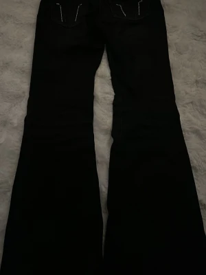 Svarta bootcut jeans från Gina Young med glitter detaljer - Säljer ett par likadana jeans som de blåa fast i svart. De är bootcut och har små glitter paljetter på bakfickorna. Jeansen har en klassisk femficksmodell och är gjorda i stretchigt denimtyg. Dessa jeansen gillar jag jättemycket men säljer dem för jag tycker dom sitter lite för stort på mig.💗