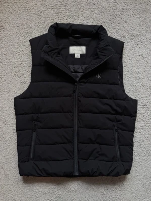 CALVIN KLEIN VÄST   - Säljer denna väst då den inte passar mig längre. Använd max 5 gånger, som ny skick.  Köpt förra året på Calvin Klein butik. För mer bilder eller frågor är det bara att skriva! 