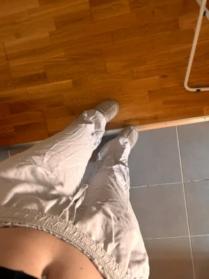 Beiga linnebyxor  - Snygga beiga linnebyxor med avslappnad passform och resår i midjan. Byxorna har raka ben och sidofickor, perfekta för en chill och trendig look. Tillverkade i lätt och luftigt linnematerial.