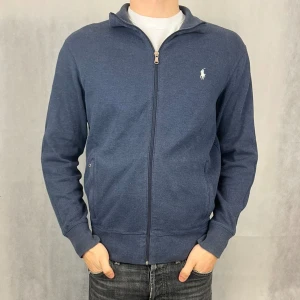 Ralph lauren fullzip  - Skön fullzip från raffe i fint skick. Modellen på bilden är 185 och bär storlek M.                                                            Defekt: dragkedjan funkar men den lilla ”flärpen” man håller i har gått sönder. Men dragkedjan funkar fortfarande lika bra 