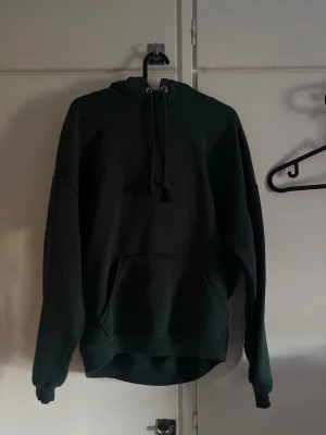 Mörkgrön oversized hoodie - En stilren mörkgrön hoodie med luva. Säljes för att den knappt används, nästan som ny! 