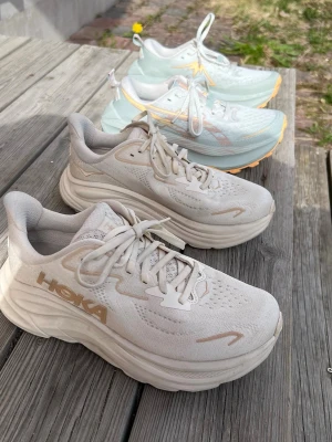Hoka Clifton 10 + ASICS Trabuco Max 4 - nyskick - Löparskor i nyskick (Hoka + ASICS)  Säljer två par löparskor som båda endast är använda 1 gång - i princip nyskick.  Hoka Clifton 10 - strl 37,5 Nypris 1699 kr  ASICS Trabuco Max 4 (trail) - strl 38 Nypris 1399 kr  Båda är mycket bekväma och redo för löpning eller promenader. Inga skador eller synligt slitage.  Pris: 1100 kr (Hoka) 900 kr (ASICS) eller 1800 kr för båda tillsammans  Kan skickas eller mötas upp enligt överenskommelse. Svarar snabbt vid intresse