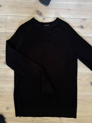 Svart stickad tröja från H&M - Svart stickad tröja från H&M i modellen Muscle Fit. Tröjan har rund halsringning, långa ärmar och ribbstickad struktur. Perfekt för dig som gillar en enkel och stilren look med en tightare passform.