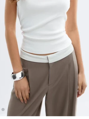 Vit ärmlös linnetopp - Snygg vit ärmlös linnetopp med figurnära passform. Toppen har en enkel och stilren design som passar perfekt till många olika outfits. Tillverkad i mjukt material som känns skönt mot huden.