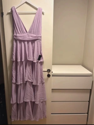 Ljuslila långklänning med volanger - Säljer denna lila volang klänning som jag hade på min bal, använd 7 timmar, kommer från Lulu’s!