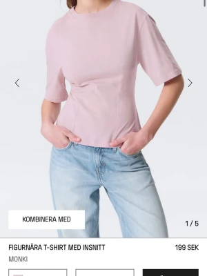 Ljusrosa figurnära t-shirt från Monki - Supersnygg ljusrosa t-shirt från Monki med figurnära passform och insnitt som framhäver midjan. T-shirten har korta ärmar och är gjord i mjuk bomull, perfekt till jeans eller kjol. Aldrig använd, bara testat!💗