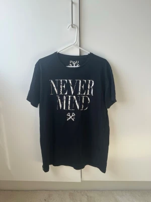 Svart t-shirt med tryck - Cool svart t-shirt med vit text ’Never Mind’ Klassisk passform och rund halsringning, perfekt för en avslappnad streetstil.