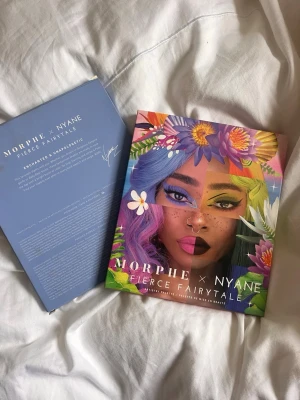 Morphe X Nyane Fierce Fairytale Artistry Palette - ”A 30-pan eyeshadow book of mattes and shimmers in unapologetically bold rainbow hues.”  Både skimriga och matta färger. Magiska dryga färger som kräver lite produkt för att ge färg. SPARSAMT använd, endast några färger som är lite testade från. Har haft plastskyddet på annars (på tredje bilden) och originalkartongen är kvar. 
