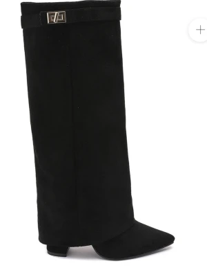 Svarta knähöga mockastövlar - Stilrena svarta stövlar i mocka med knähögt skaft och spetsig tå från. Dekorativt spänne upptill och låg klack. Dragkedja på insidan för enkel påtagning. Perfekta för en trendig look.