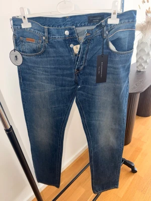 Baldessarini - Snygga blå jeans från Baldessarin med klassisk rak passform och knäppning med knappar. Jeansen är gjorda i mjuk egyptisk bomull och har diskreta slitningar för en cool look. Perfekta till vardagsstilen och funkar året runt storlek 36/34