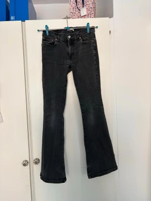 Svarta bootcut jeans från Gina - Snygga svarta bootcut jeans från Gina med klassisk fyrfickdesign. Jeansen har en lätt utsvängd passform nertill och är tillverkade i denim med en tvättad look. Perfekta för en trendig och avslappnad stil.