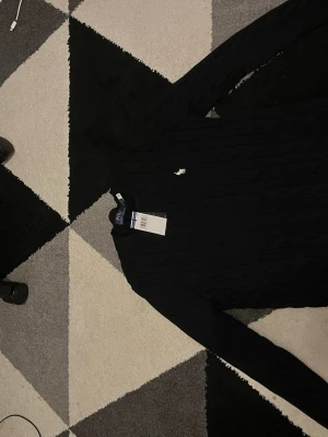 Polo ralp lauren tröja  - Säljer svart med vit badge polo ralp lauren stickat tröja. Den är helt ny storlek s 