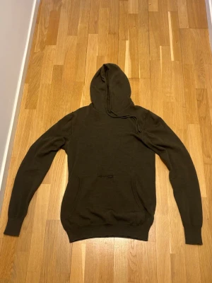 Stickad hoodie - Schysst stickad hoodie från J.Lindeberg i merino ull. Finns ett litet hål på framsidan vid fickan men går nog att lämna in och laga enkelt. Kontakta mig vid fler frågor!