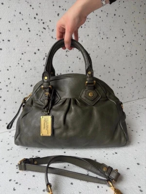 Mörkgrön Marc Jacobs väska - Säljer en mörkgrön vintage Marc Jacobs väska med guldiga detaljer. Väskan är i fint skick utan några defekter. Observera att väskan är fylld på bilderna Hör av dig vid intresse!Säljer en mörkgrön vintage Marc Jacobs väska med guldiga detaljer. Väskan är i fint skick utan några defekter. Observera att väskan är fylld på bilderna Hör av dig vid intresse!