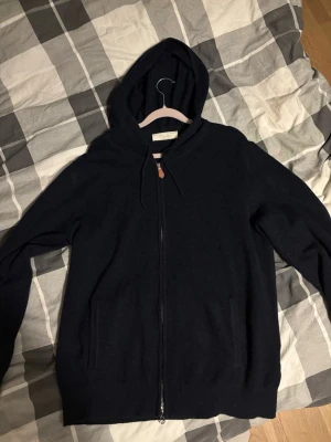 Mörkblå hoodie med dragkedja - Snygg mörkblå hoodie från sayless med dragkedja framtill och två fickor. Klassisk modell med huva och dragsko. Tillverkad i mjukt material som känns skönt mot huden. Perfekt för en avslappnad och stilren look. Storlek S sitter mer som m.