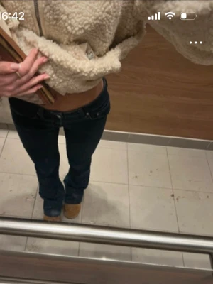 Mörkblå low waist bootcut jeans - Säljer ett par mörkblå low waist jeans med bootcut-modell. Jeansen har klassisk femficksdesign och sitter tight över höfterna för en snygg siluett. Perfekta för dig som gillar 00-talsvibbar och vill ha ett par trendiga jeans i garderoben.