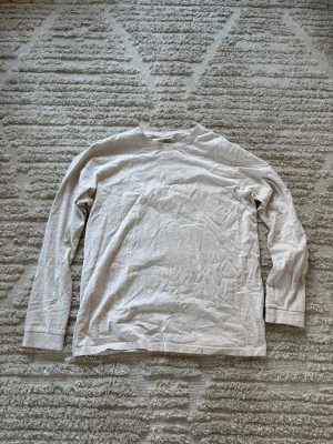 Beige långärmad tröja från lager 157 - En basic beige långärmad tröja från lager 157 i mjukt bomullstyg. Tröjan har rund halsringning och raka ärmar, perfekt för en enkel och clean stil. 