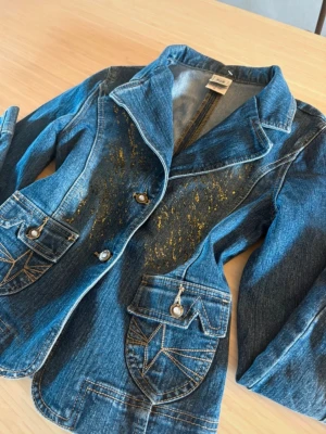Y2K vintage jeans jacka - Super fin jeansjacka som tyvärr inte kommer till användning. Den har riktigt fina detaljerade fickor och guldigt glitter både fram och bak. Finns inga skador eller defekter🫶🏻  Står ingen storlek men jag uppskattar det som en XS/S, alla mått finns på sista bilden💞