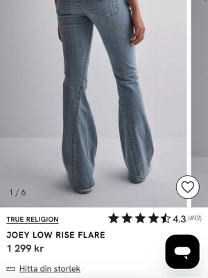 True Religion Joey Low Rise Flare jeans - Säljer ett par ljusblåa flare jeans från True Religion, modellen Joey Low Rise Flare. Jeansen har låg midja, utsvängda ben och klassiska bakfickor med broderad logga. Tillverkade i denim med snygg tvätt och detaljerade sömmar.