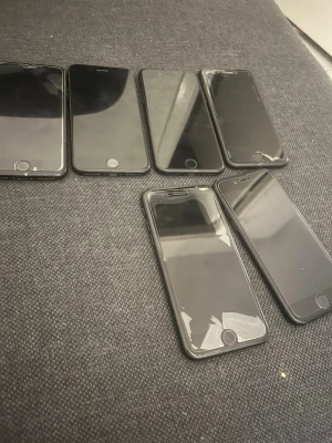 6 st svarta iPhone 7 - Säljer ett gäng svarta iPhone 7 med klassisk rund hemknapp och stilren design. Alla har en matt svart baksida i aluminium och Apple-loggan. Perfekt för dig som gillar enkel och snygg look. Skärmarna är plana och telefonerna har rundade hörn.