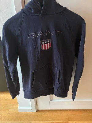 Mörkblå hoodie från GANT - Storlek 158-164cm! Väldigt bra skick! Sparsamt använd! Nypris 899 kr! Mitt pris 249 kr! Kan gå ner lite vid snabb o enkel affär! Kan även köpas tillsammans med andra kläder för billigare pris! Tveka inte på att höra av er om ni har några funderingar!