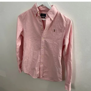 Rosa skjorta från Ralph Lauren - En otroligt bekväm och Sjukt Snygg Rosa skjorta från Ralph Lauren i storlek XS. Nästan nyskick, inga defekter.