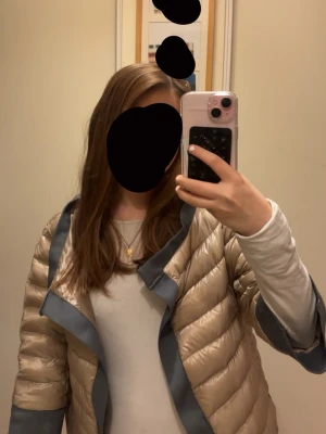 Beige dunjacka från Herno - Snygg beige dunjacka från Herno med glansigt material och kontrasterande gråblå detaljer längs kanterna. Perfekt om du gillar Stockholmstil. ‼️ JAG ÄR VILLIG ATT DISKUTERA PRISET VID SNABB AFFÄR‼️