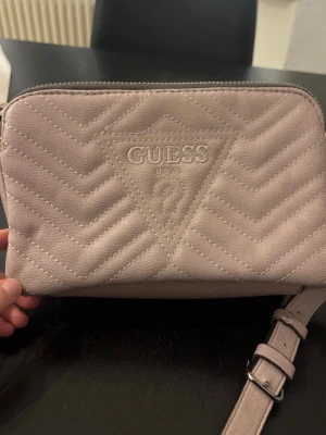 Guess handväska - Säljer min jättefina guess handväska i rosa/lila! I jättebra skick då den knappt är använd!