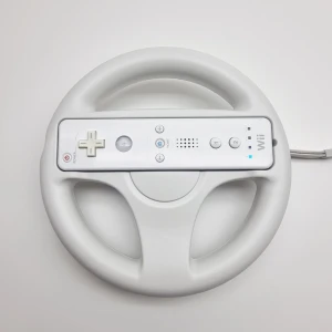 Nintendo Wii Wheel / Ratt - Wii ratt för användning med Wii-konsolen.   Ratten är utformad för att ge en mer engagerande körupplevelse i kompatibla spel. Den är vit och har en central öppning för att fästa en Wii Remote-kontroll.  (Wii Remote kontrollen är som visningsexpempel. Annonsen gäller endast för ratten)