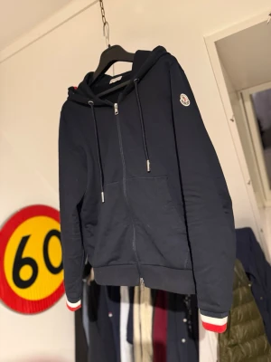 Marinblå hoodie från Moncler - Snygg marinblå hoodie från Moncler mycket fint skick. Storlek M. Vid någon fundering är de bara att skriva, ge gärna prisförslag!