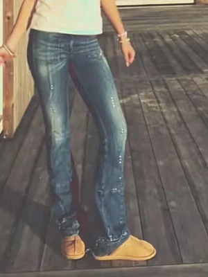 Blå bootcut lågmidjade jeans med nitar - Snygga blå bootcut jeans med slitningar och små silverfärgade nitar längs benen. Jeansen har låg midja, dekorficka med dragkedja och markerade sömmar. Perfekta för en trendig och avslappnad stil. Är lite sönder vid sidorna och har sytt så att de är längre därför är de lite slitna längst ner! Pris kan diskuteras vid snabb affär! 💗
