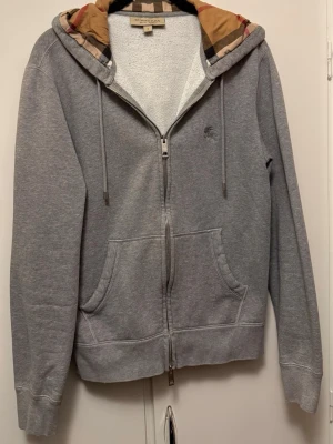 Grå zip-hoodie från Burberry - Snygg grå hoodie från Burberry i bra skick. Skriv gärna vid funderingar.