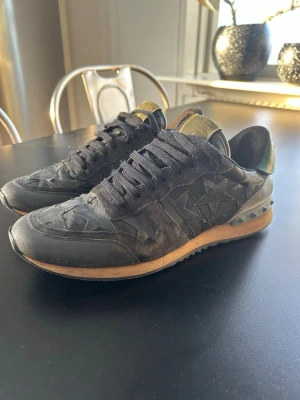 Svarta sneakers från Valentino - Snygga svarta sneakers från Valentino med stjärnmönster på sidorna och coola nitar på hälen. Skorna har svart mocka och läderdetaljer. Pris kan diskuteras!
