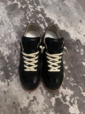 Maison margiela gats - Helt nya svarta Maison margiela gats i storlek 43, köpta från nk, kvitto tillkommer samt dustbagsen,  boxen medföljer tyvärr inte, innersulan är 28cm, hojta till vid funderingar!