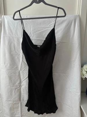 Svart kort slipklänning med smala band - Svart slip dress i satinliknande material från Bershka 🖤  Elegant och tidlös modell med tunna justerbara axelband och fint fall. Perfekt till fest, middag eller utekväll - men kan aven stylas mer casual med t.ex. sneakers och kavaj.  • Storlek: L  • Märke: Bershka • Justerbara band • Mjukt, glansigt material • Endast testad, aldrig använd så i fin skick.     #slipdress #satinklanning #bershka #svartklanning #festklänning #minidress #y2k #minimal #cleangirl #party #evening #satin #klänning 