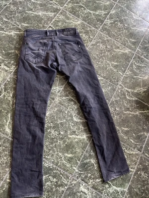 Replay Grover - Ett par Svart/Gråa Replay i model Grover. Dem är straight fit. Storlek W30 L34. Nyrpris runt 1000kr. Bra skick, liten defekt på baksidan nedanför, som knappt märks vid användning. Hör av dig vid flera frågor eller bilder