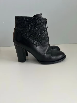 Svarta & Other Stories stövletter / boots, äkta skinn - Snygga svarta boots / stövletter från & Other Stories i äkta skinn / läder. Storlek 40. Cool dragkedja fram och strukturerad överdel. Klassiskt rundad tå, och stabil klack. Kvalitetsskor i mycket gott skick. Nypris 1800:-
