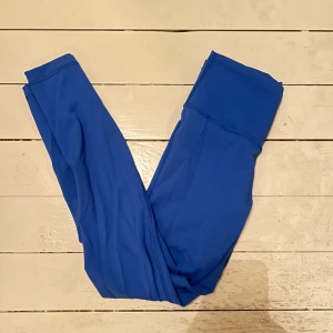 Blå Lululemon tights - Säljer eftersom jag har för mycket träningskläder och dessa kommer inte till användning. De är i fint skick tror jag använt de fem gånger totalt. Storlek 6, skulle säga att det passar en S. De har också en lululempn logga på benet. Bara att skriva för fler bilder! Andra och tredje bilden visar färgen bäst. Nypris på runt 1000